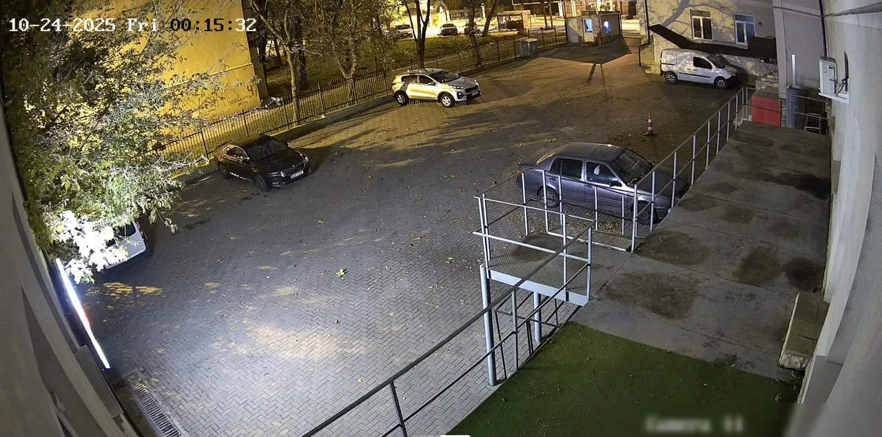 Камера видеонаблюдения на парковке во дворе, ночью